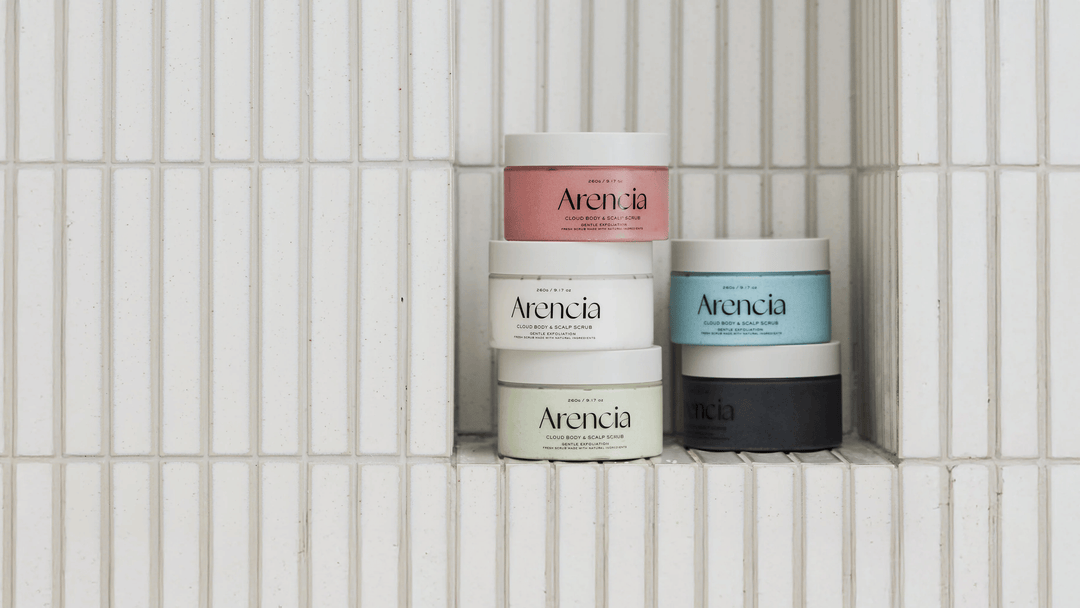 Arencia Cloud Body & Scalp Scrub i flera varianter staplade på kakelhylla. Skonsam kroppsskrubb och skalpskrubb som exfolierar, rengör och ger huden en mjuk och fräsch känsla.