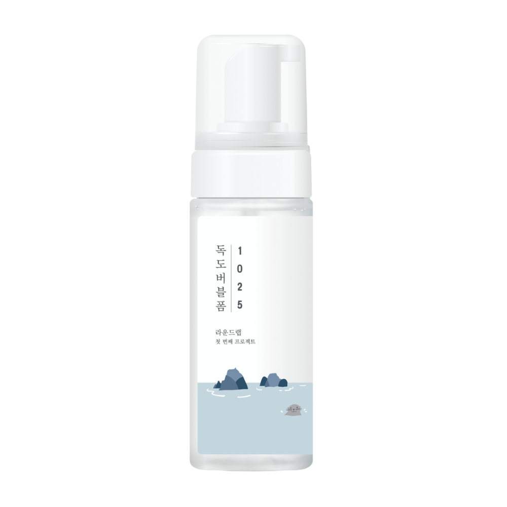 1025 Dokdo Bubble Foam" is een gezichtsreinigingsproduct van ROUND LAB, verpakt in een witte pompflacon met een eenvoudig en schoon ontwerp, versierd met tekst en minimalistische illustraties van zeegezichten. 