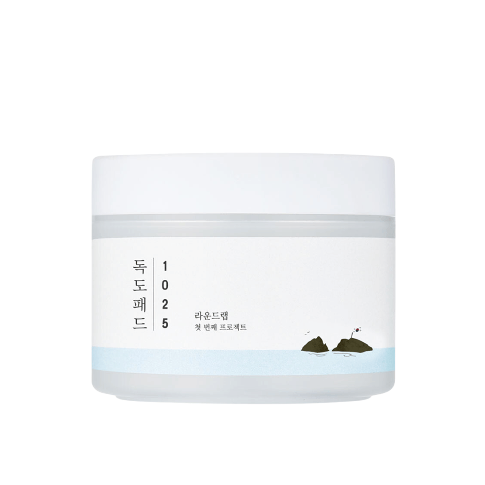 Een gesloten witte pot van 1025 Dokdo Pads met een eenvoudig ontwerp en zee motief op het etiket, tegen een witte achtergrond.