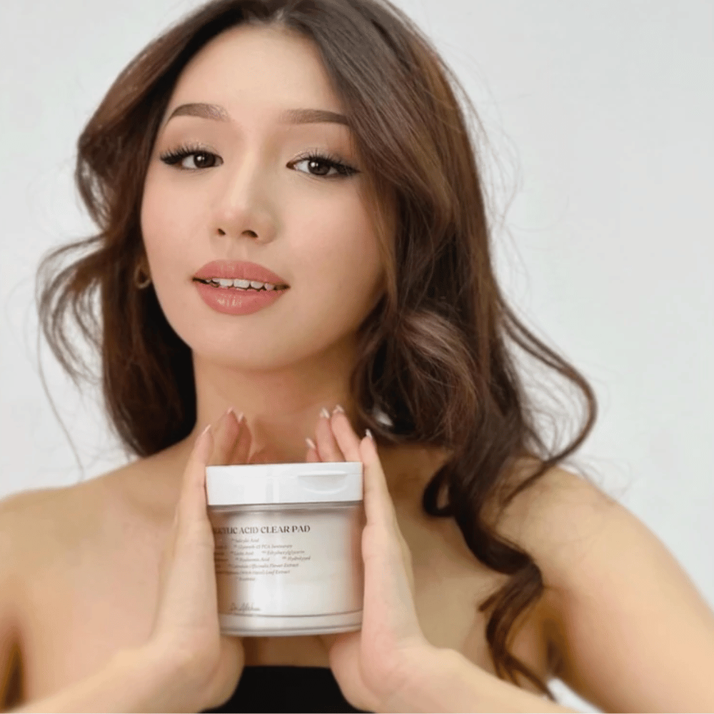 Model houdt Dr. Althea 2% Salicylic Acid Clear Pad voor het gezicht. Exfoliërende toner pads met salicylzuur die de poriën reinigen, talg balanceren en de huid helderder maken.