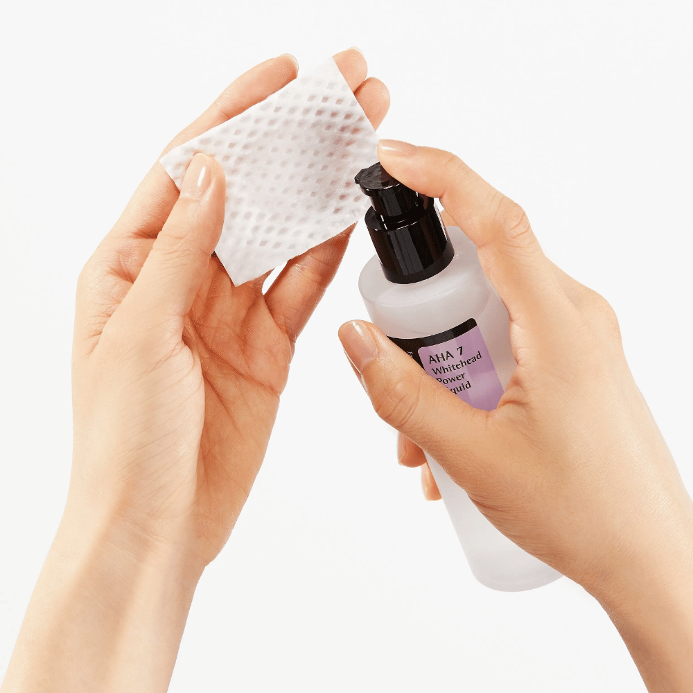 Aanbrengen van COSRX AHA 7 Whitehead Power Liquid op wattenschijfje, exfoliërende toner met AHA om dode huidcellen te verwijderen en de huidstructuur te verbeteren.