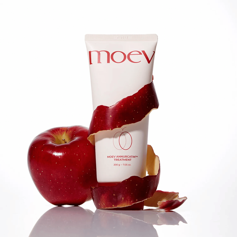 MOEV Annurcatin Treatment samen met rode appels – symboliseert de natuurlijke kracht van de Annurca-appel die het haar diep verzorgt en beschermt.