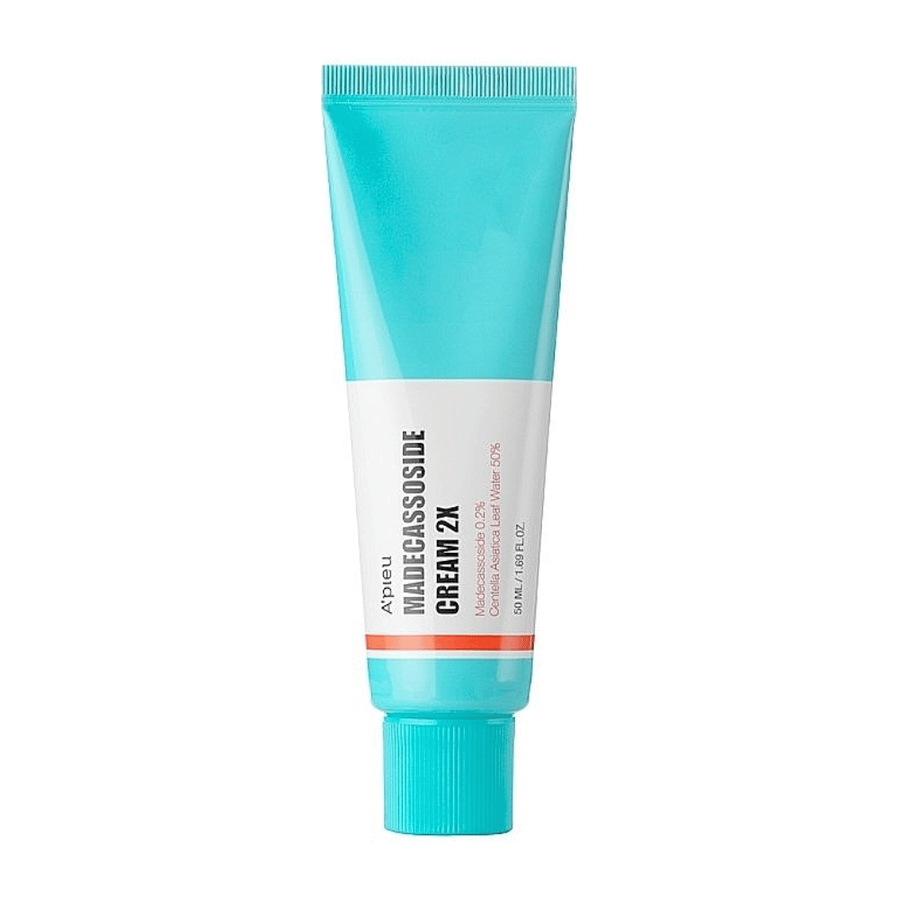 Een tube met A'PIEU Madecassoside Cream 2X, met een licht turquoise kleur aan de bovenkant die overgaat in wit naar de onderkant. De tube heeft duidelijke tekst die het merk en de productnaam aangeeft, evenals het actieve ingrediënt Madecassoside 2%. Een oranje accentkleur loopt als een streep rond de tube. Het product lijkt een huidcrème te zijn gericht op huidverzorging en herstel. De achtergrond is neutraal om de focus op het product te houden.