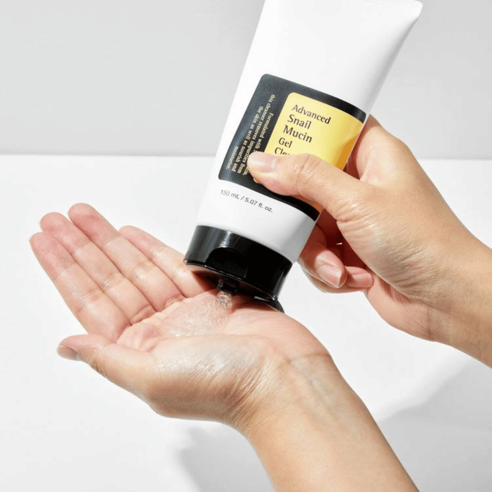 Hand brengt COSRX Advanced Snail Mucin Gel Cleanser aan – milde gelreiniger met slakkenslijm die diep reinigt en de vochtbalans van de huid behoudt.