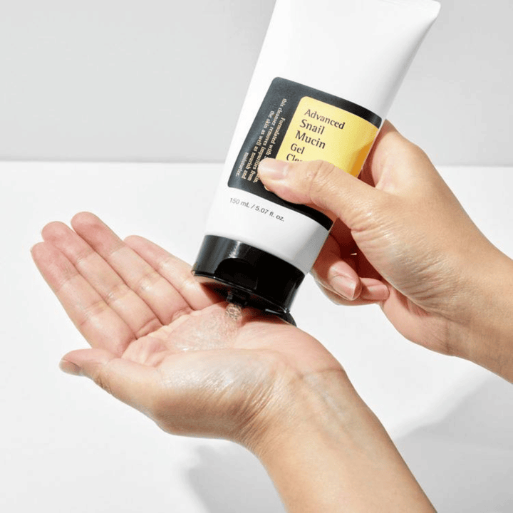 Hand brengt COSRX Advanced Snail Mucin Gel Cleanser aan – milde gelreiniger met slakkenslijm die diep reinigt en de vochtbalans van de huid behoudt.