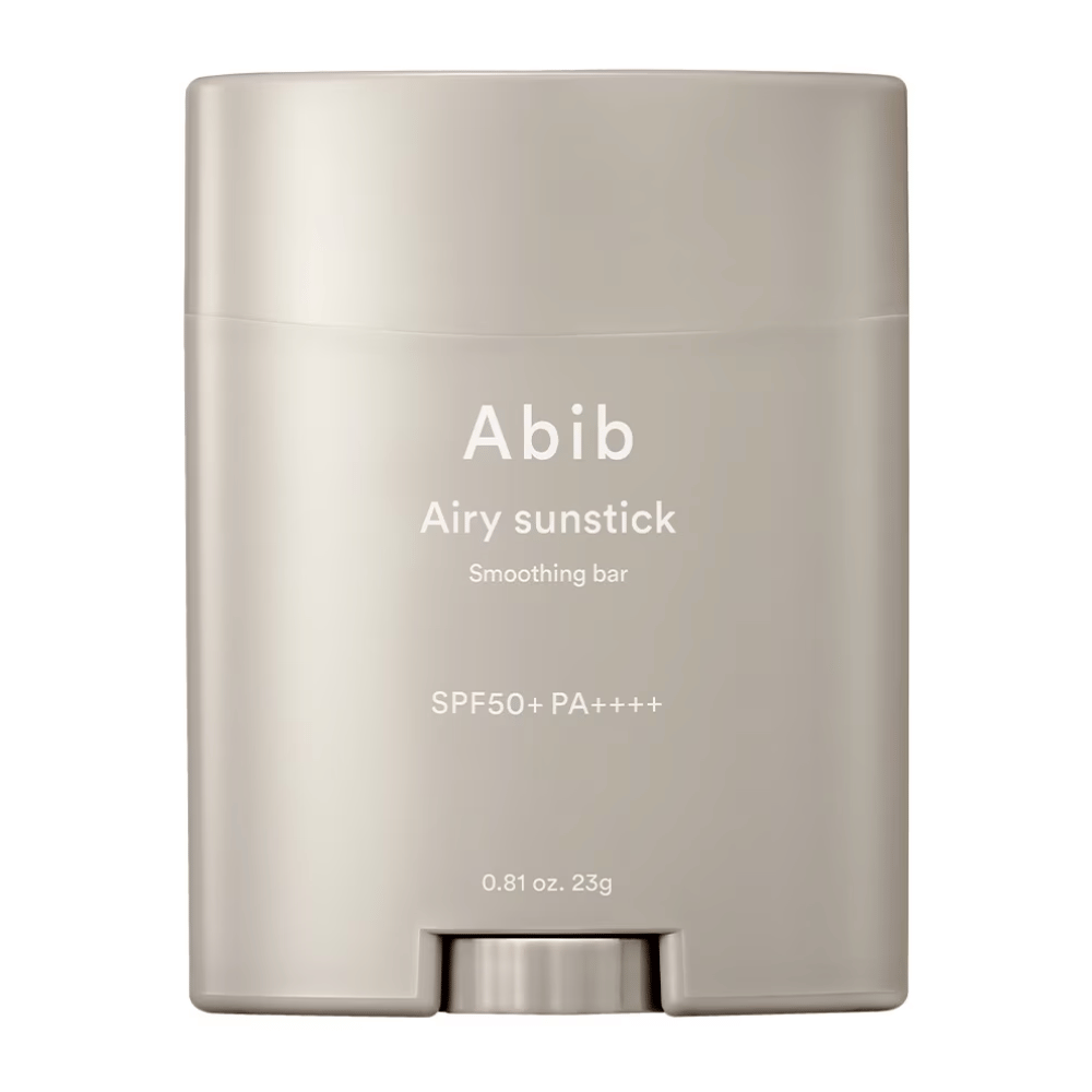 De afbeelding toont een beige zonnebrandstick van Abib met de tekst "Airy Sunstick Smoothing Bar" en zonbeschermingsfactor SPF50+ PA++++, perfect voor dagelijkse bescherming tegen UV-stralen.