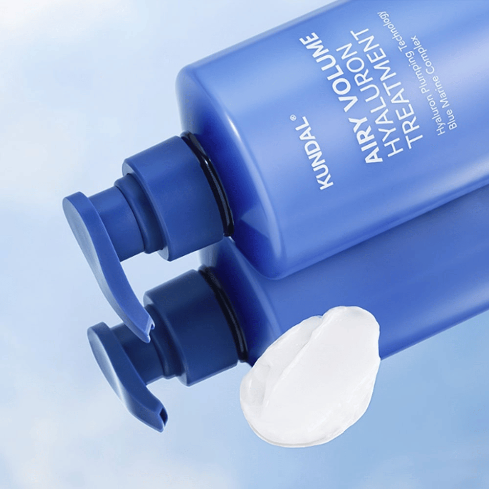 KUNDAL Airy Volume Hyaluron Treatment in blauwe pompflacon liggend, met zichtbaar wit crèmeproduct ernaast.