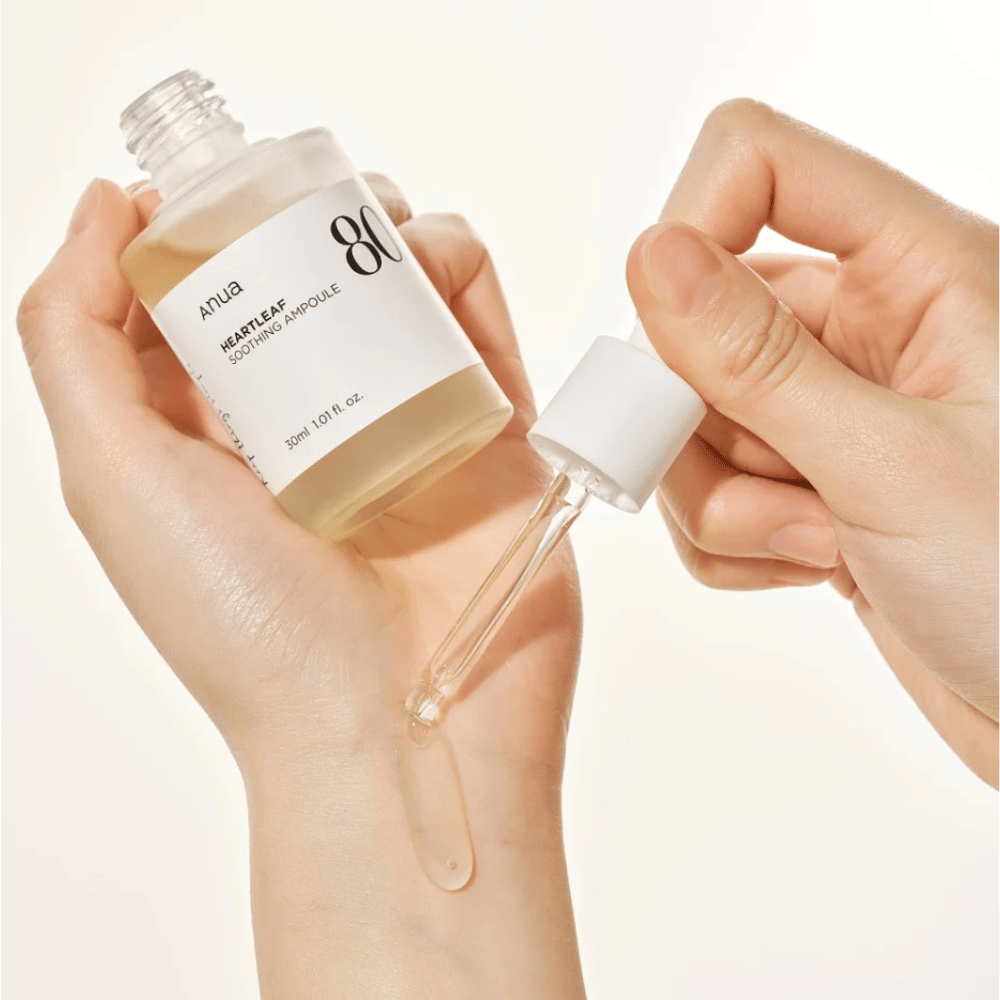 Een hand die een Heartleaf 80% Soothing Ampoule 30ml van Anua vasthoudt.