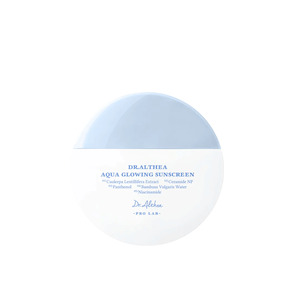 Productafbeelding van Dr. Althea Aqua Glowing Sunscreen – een ronde zonnebrandcrème in witte en lichtblauwe verpakking met blauwe tekst die hydraterende ingrediënten zoals niacinamide en ceramiden benadrukt.