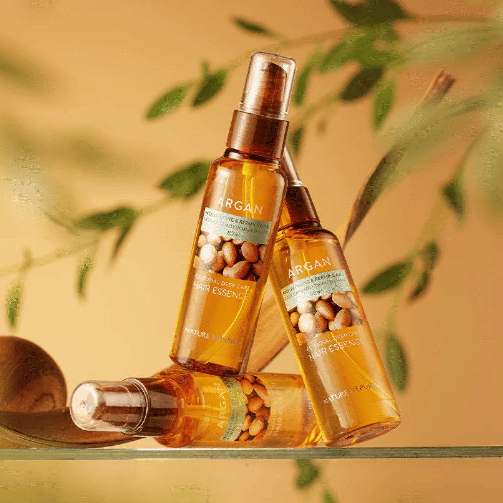 Drie flessen van Nature Republic Argan Essential Moisture Hair Oil met arganolie – biedt voeding, glans en herstelt beschadigd haar.