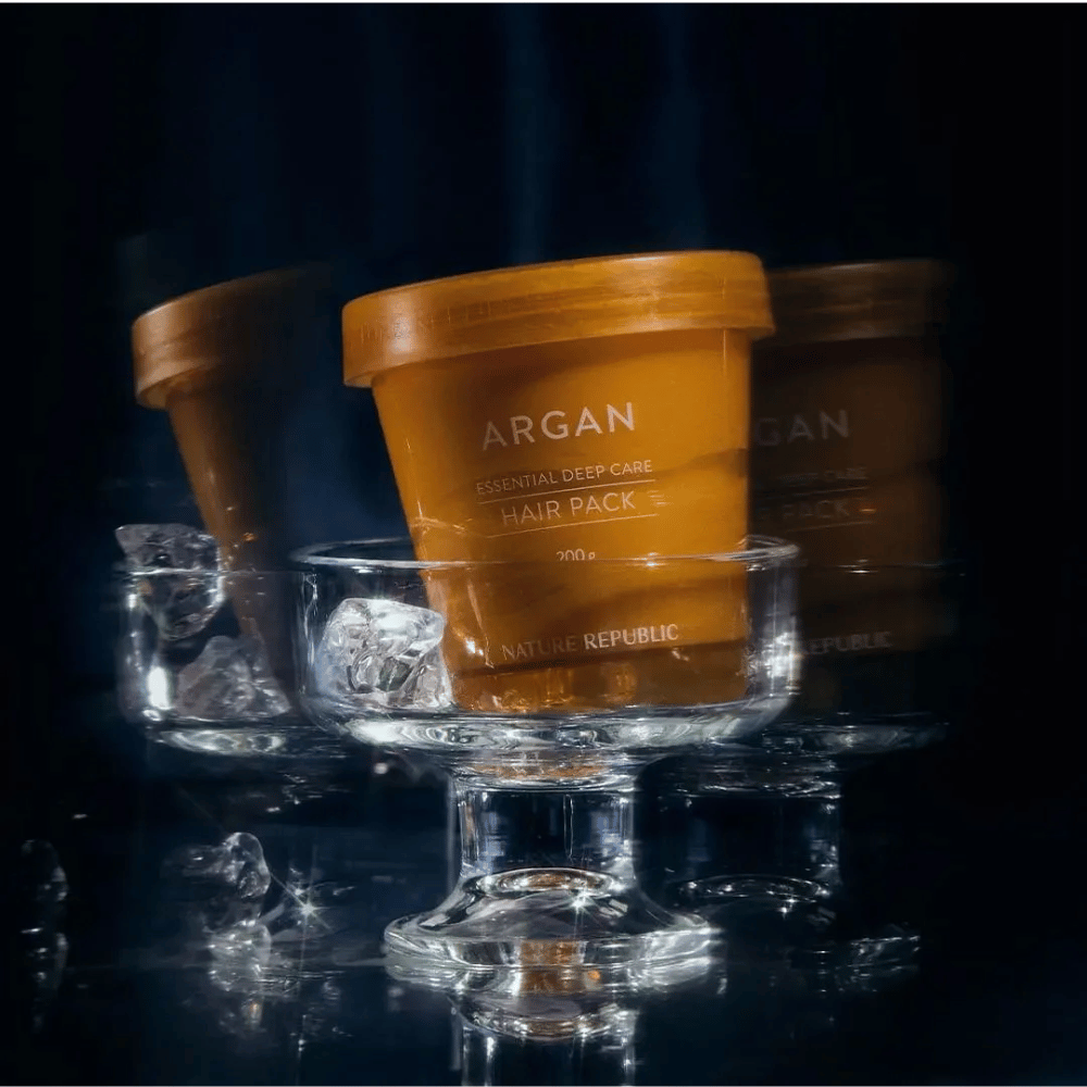 Nature Republic Argan Essential Moisture Repairing Hair Mask geplaatst op glazen schaal met ijsblokjes – luxe en verzorgend haarmasker.