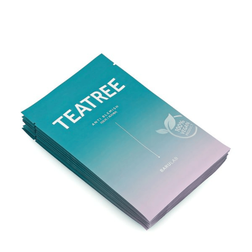 Een stapel verpakkingen van BARULAB "TEATREE Anti Blemish" maskers, allemaal gemarkeerd als "100% Vegan Product". De verpakkingen hebben een uniforme turquoise kleur.