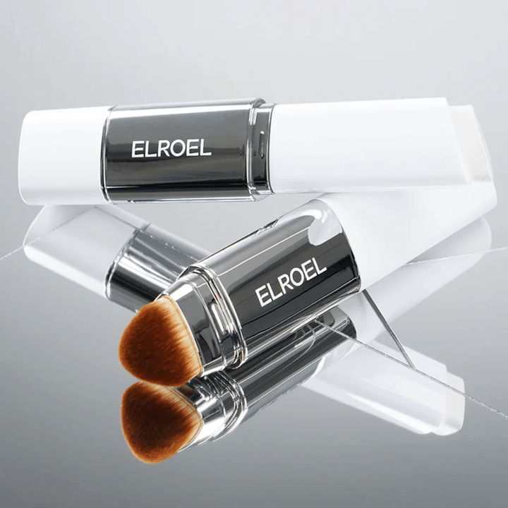 ELROEL Blanc Cover Cream Stick met geïntegreerde borstel geplaatst op spiegeloppervlak om zachte borstel en egale applicatie te tonen.