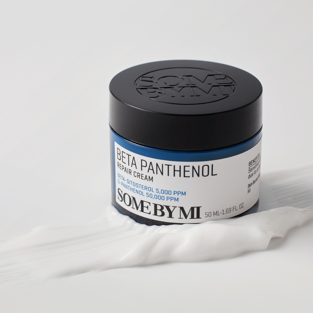 SOME BY MI Beta Panthenol Repair Cream in blauwe pot geplaatst op crème textuur – kalmerende en hydraterende huidcrème.