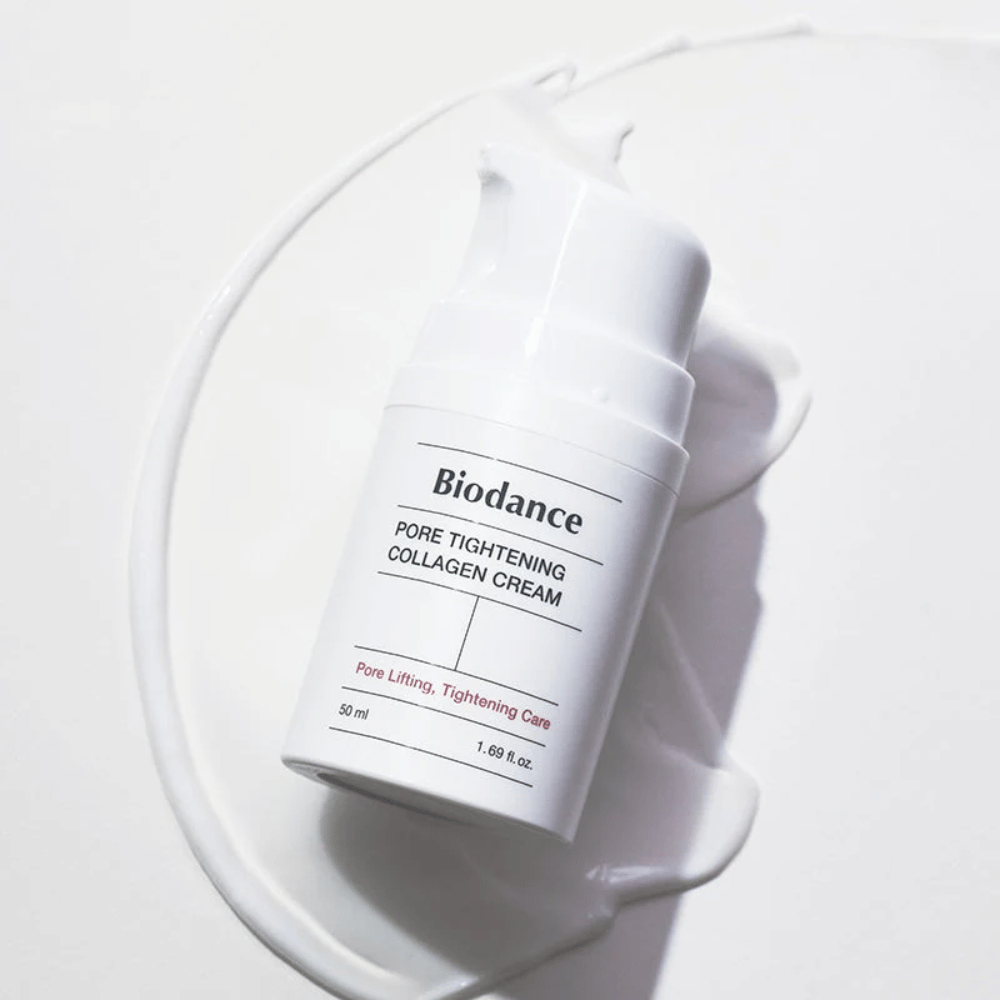 Biodance Pore Tightening Collagen Cream in een witte pompflacon, liggend op een swirl van witte crème.