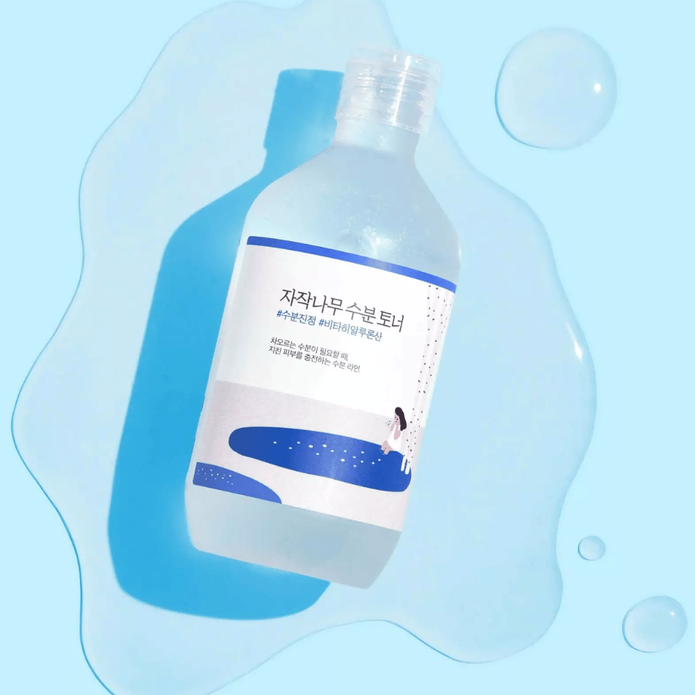 De fles ligt schuin in een waterachtige vloeistof met druppels eromheen op een blauwe achtergrond