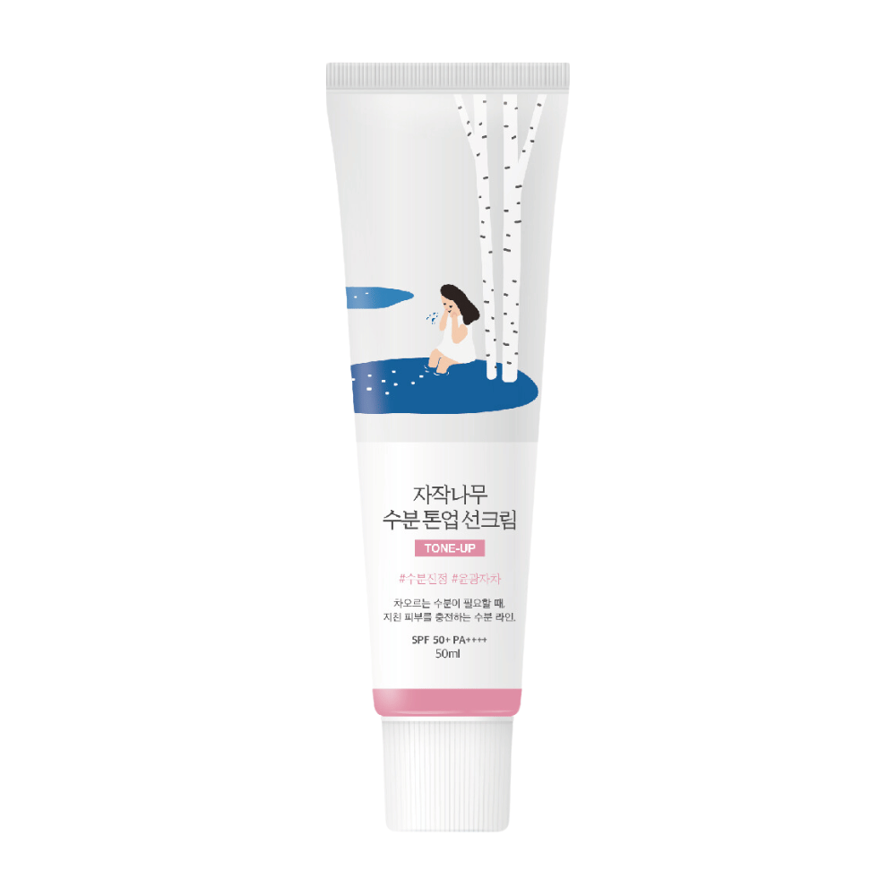 Een witte tube met Birch Juice Moisturizing Tone Up Sunscreen. De tube heeft een illustratie van een vrouw die bij een berk naast een plas water zit. De tekst op de tube is in het Koreaans en geeft aan dat het product SPF 50+ PA++++ heeft en 50 ml bevat.