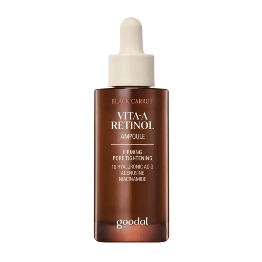 De fles met Goodal Black Carrot Vita-A Retinol Firming Ampoule wordt getoond. Het heeft een beige pipet en een donkerbruine fles. Het etiket beschrijft het product als "Vita-A Retinol Ampoule" en vermeldt eigenschappen zoals "Firming Pore Tightening", evenals de ingrediënten 10% hyaluronzuur, adenosine en niacinamide.