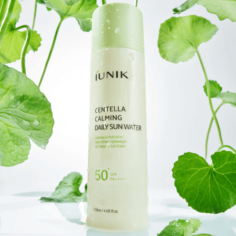 2. iUNIK Centella Calming Daily Sun Water SPF50+ PA++++ – hydraterende zonbescherming met centella asiatica, omringd door groene bladeren en waterdruppels