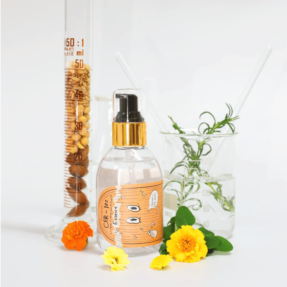 CER-100 Hair Essence samen met bloemen en laboratoriumglaswerk dat de ingrediënten en haarverzorging benadrukt.