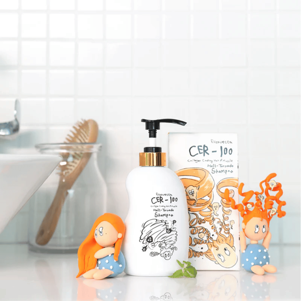 Elizavecca CER-100 Shampoo en doos worden getoond in een badkameromgeving naast een haarborstel en decoratieve figuren. De afbeelding brengt een alledaagse haarverzorgingsroutine en het gebruik van het product in een thuisomgeving over.