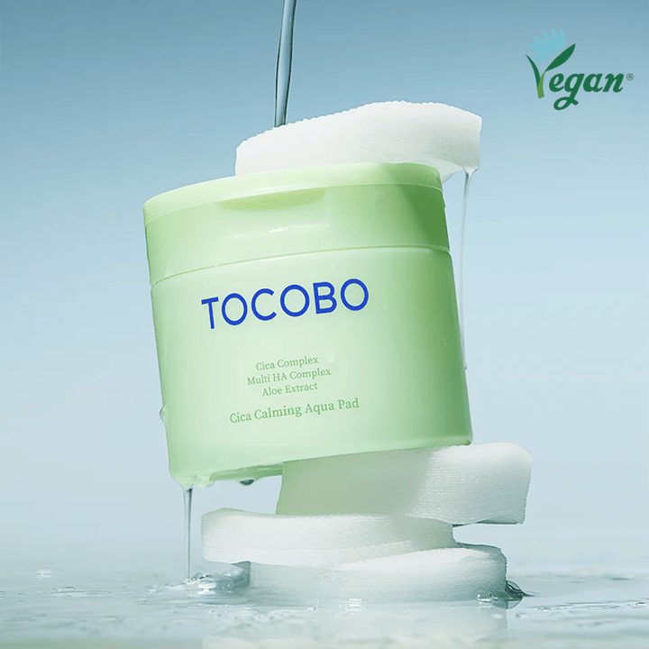 TOCOBO Cica Calming Aqua Pad geplaatst tussen tonerpads met stromende essence. Het vegan-symbool benadrukt de veganistische formulering van het product en het huidvriendelijke profiel.