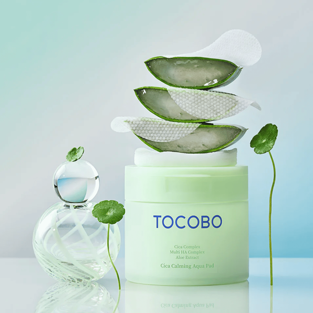 TOCOBO Cica Calming Aqua Pad wordt getoond samen met tonerpads, aloë vera en centella asiatica. De afbeelding benadrukt de hydraterende en kalmerende ingrediënten van het product.