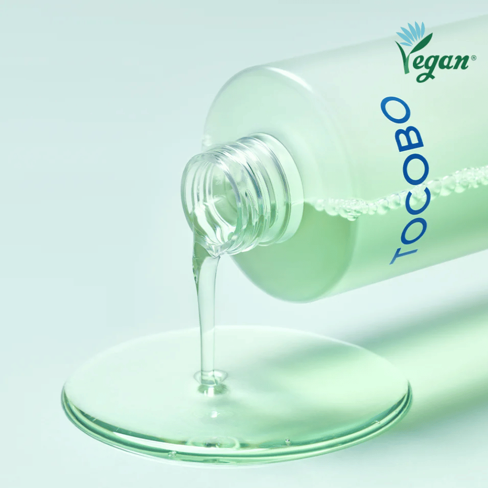 Close-up van TOCOBO Cica Calming Aqua Toner die wordt uitgegoten om de heldere, lichte en verkoelende textuur van het product te benadrukken.