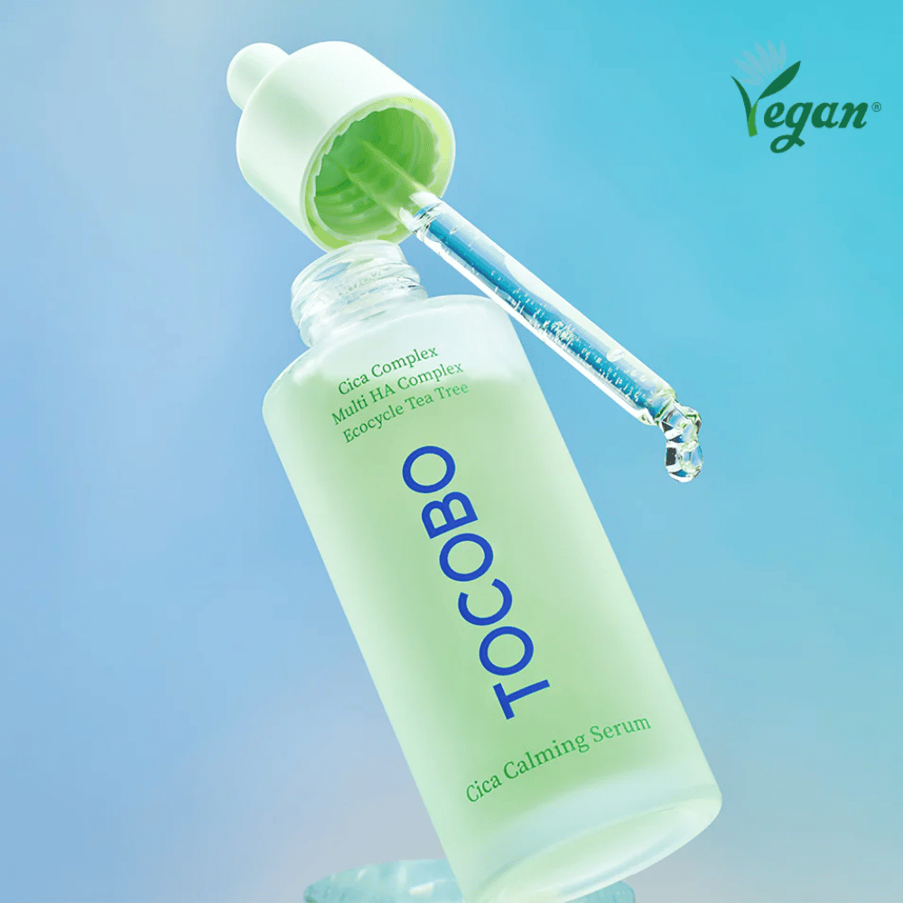 TOCOBO Cica Calming Serum met pipet tegen blauwe achtergrond, licht absorberend K-beauty serum dat de huidbarrière versterkt en geschikt is voor gevoelige, vette en acnegevoelige huid.