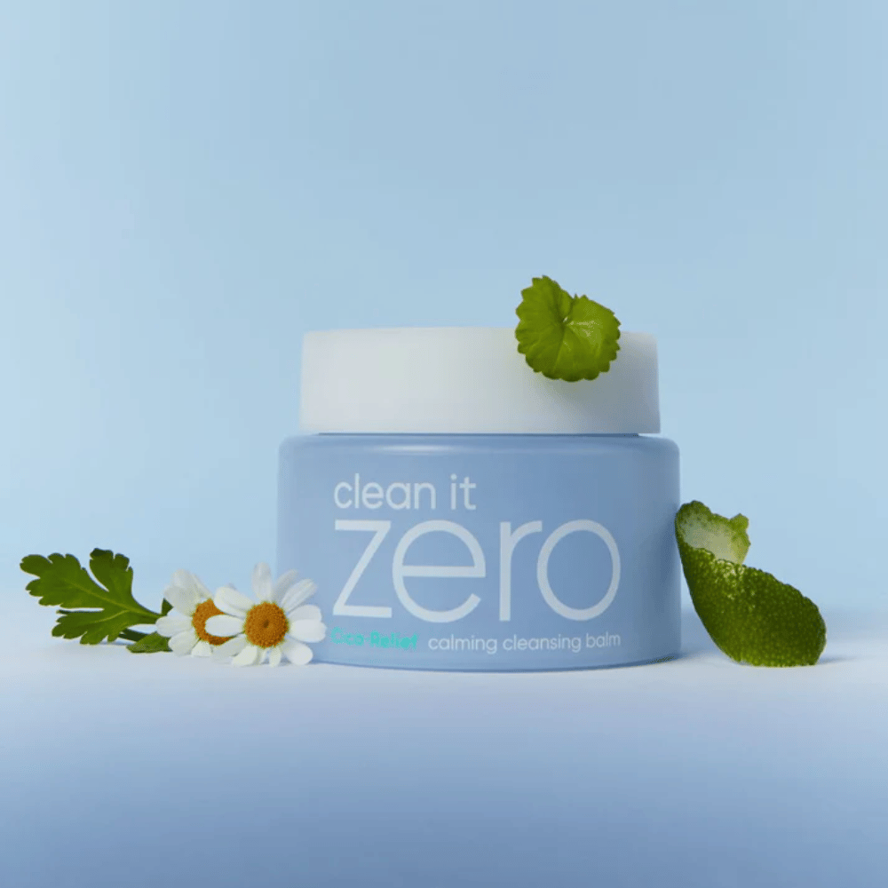 Clean It Zero Cica-Relief Calming Cleansing Balm geplaatst met planten en bloemen, illustreert milde reiniging met kalmerende CICA voor gevoelige en geïrriteerde huid.