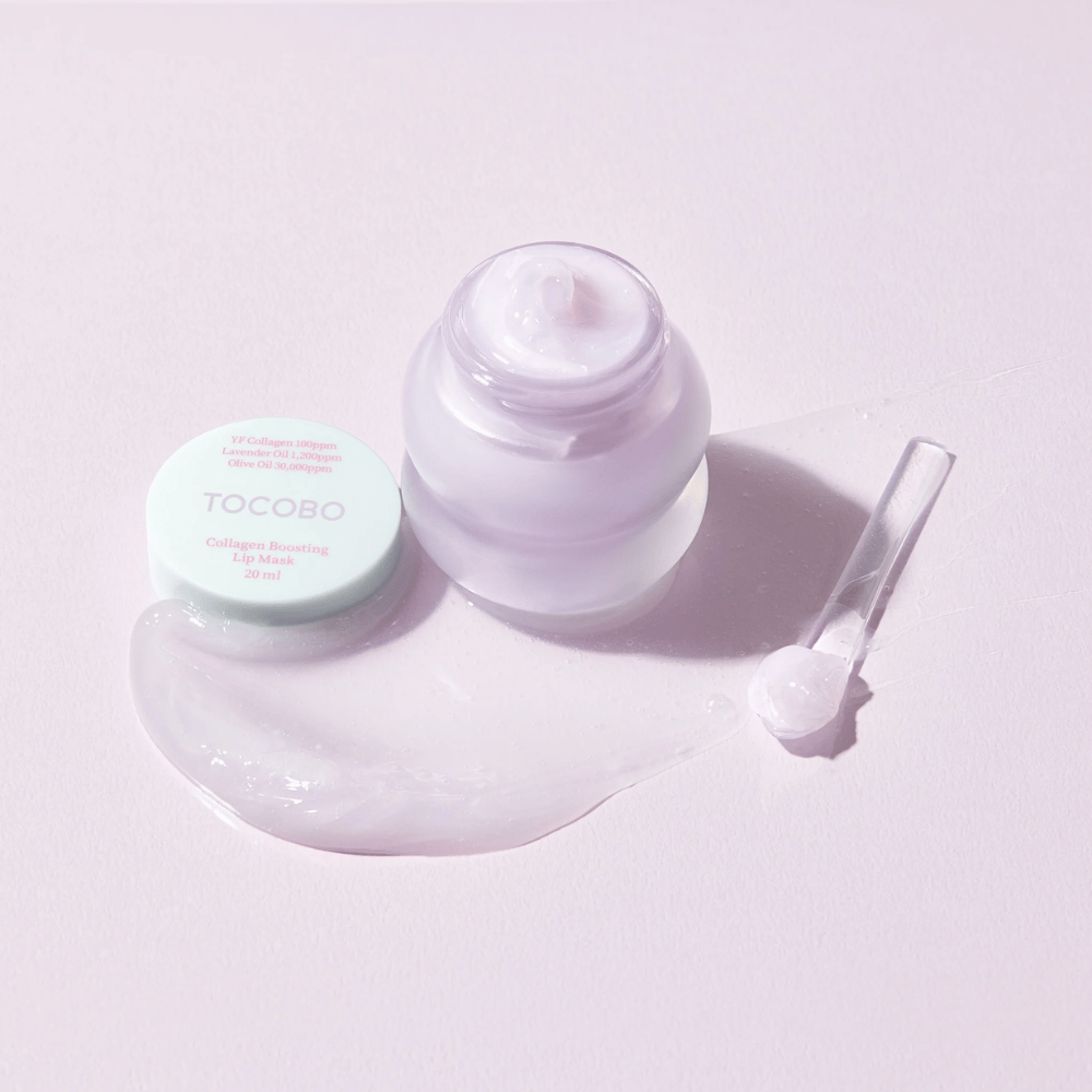 Open pot TOCOBO Collagen Boosting Lip Mask met spatel en verspreide paarse crème op lichtpaarse achtergrond.