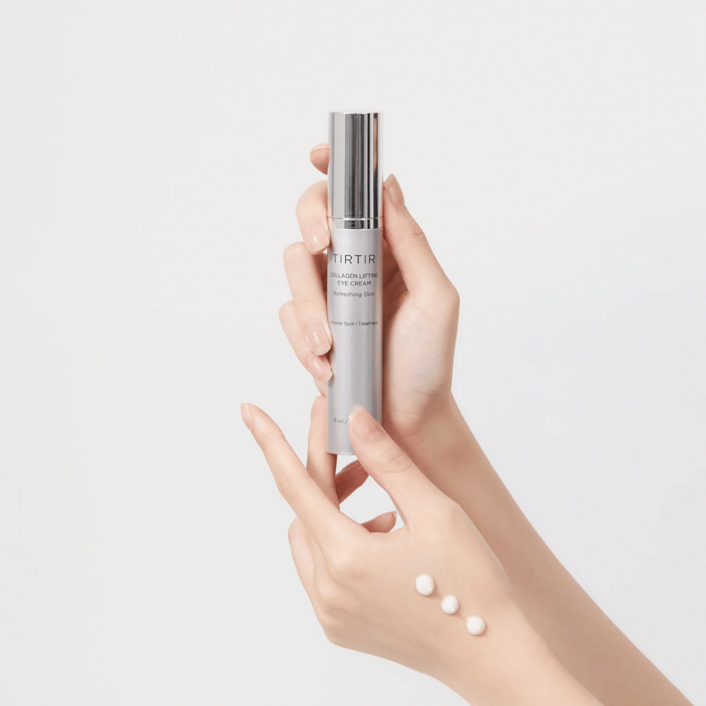 Handen die een tube met TIRTIR Collagen Lifting Eye Cream vasthouden, met product uitgeperst op de rug van de hand.