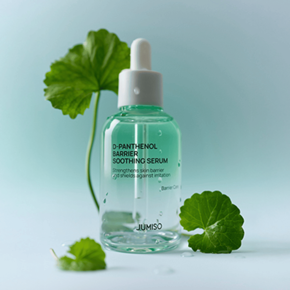 Jumiso D-Panthenol Barrier Soothing Serum in een doorzichtige glazen fles met pipet, geplaatst met groene bladeren op de achtergrond.
