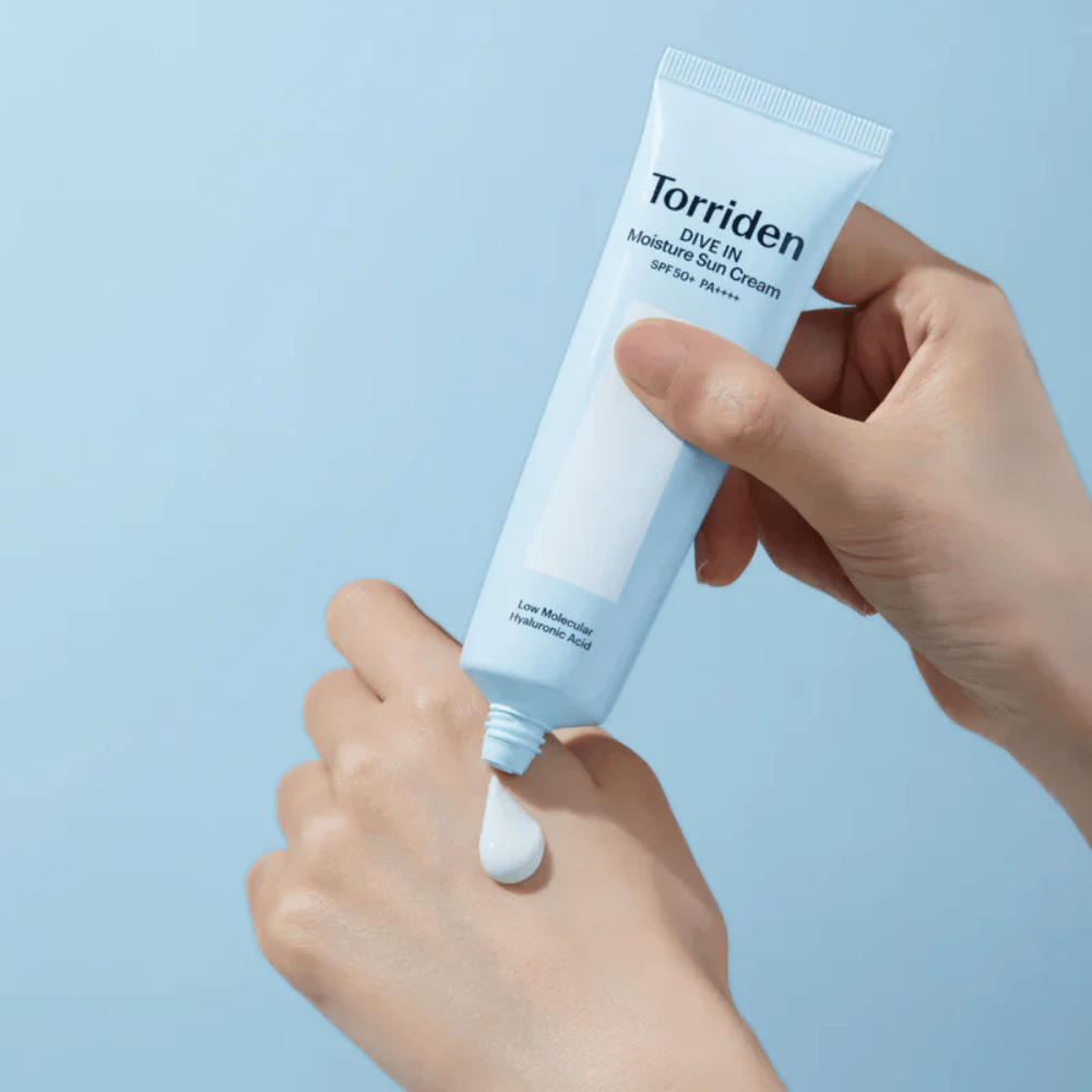 Torriden DIVE-IN Moisture Sun Cream SPF50+ PA++++ wordt op de hand aangebracht om de lichte en romige textuur van de hydraterende zonnecrème te tonen.