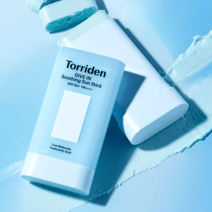 Torriden DIVE IN Soothing Sun Stick SPF50+ PA++++ samen met uitgesmeerde producttextuur die de hydraterende en lichte applicatie illustreert.