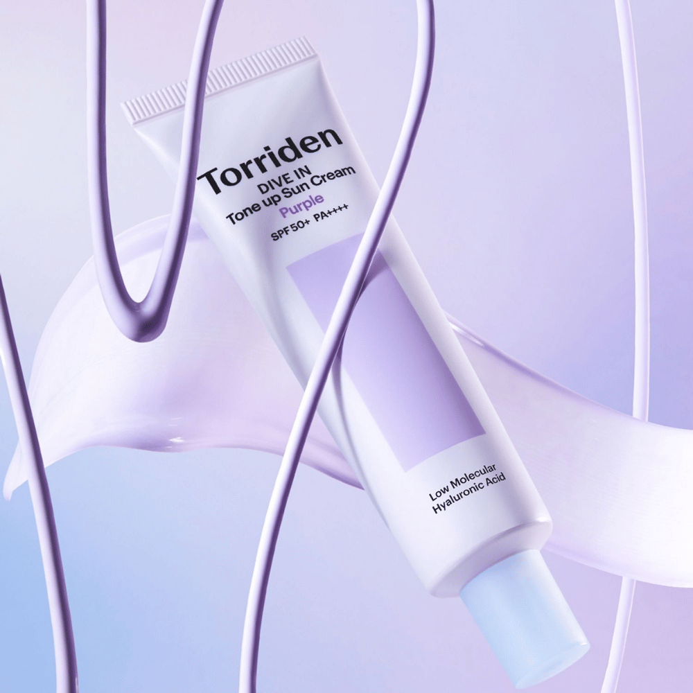 Torriden DIVE IN Tone Up Sun Cream Purple SPF50+ PA++++ gepresenteerd in een creatieve productsetting met paarse details die de hydraterende formule benadrukken.