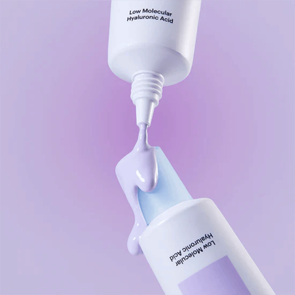 Close-up van Torriden DIVE IN Tone Up Sun Cream Purple waarbij de paarse crème uit de tube wordt aangebracht om de textuur van het product te illustreren.