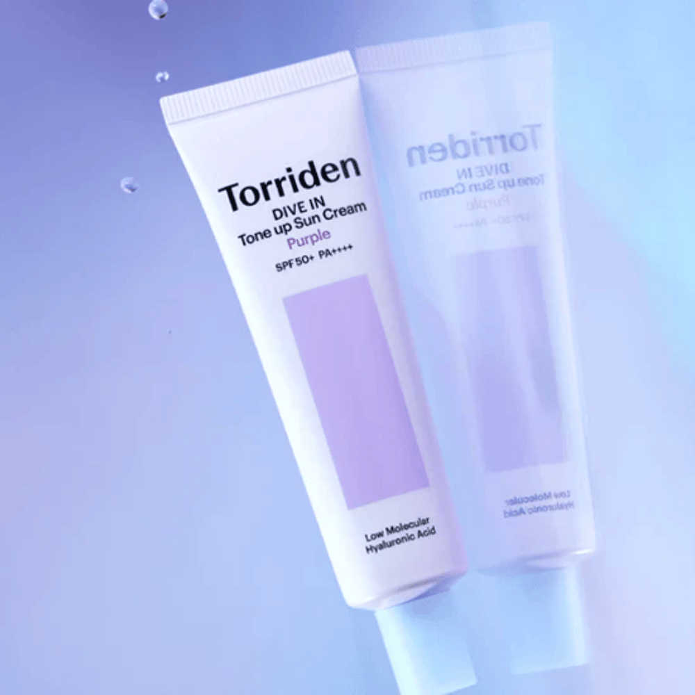 Torriden DIVE IN Tone Up Sun Cream Purple SPF50+ PA++++ gefotografeerd tegen een zachte paarse achtergrond die het lichtreflecterende ontwerp van het product benadrukt.