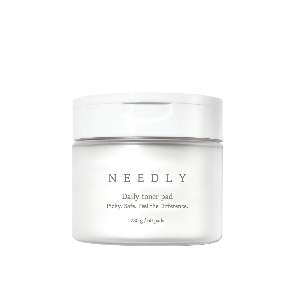 Een witte pot met Needly Daily Toner Pad. De verpakking heeft minimalistische tekst die het product beschrijft en bevat 280 g, wat overeenkomt met 60 toner pads. De tekst luidt 'Picky. Safe. Feel the Difference.