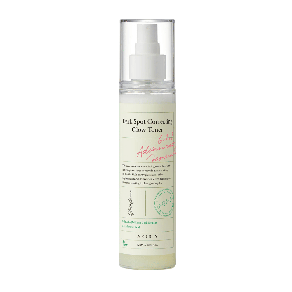Een afbeelding van een fles van het product "AXIS-Y Dark Spot Correcting Glow Toner". De fles is doorzichtig met een wit etiket en tekst in zwart en groen. Het product is een toner in sprayvorm en de fles bevat 125 ml (4,23 fl. oz). Het etiket vermeldt sleutelingrediënten zoals Wilgenschors Extract en Hyaluronzuur.