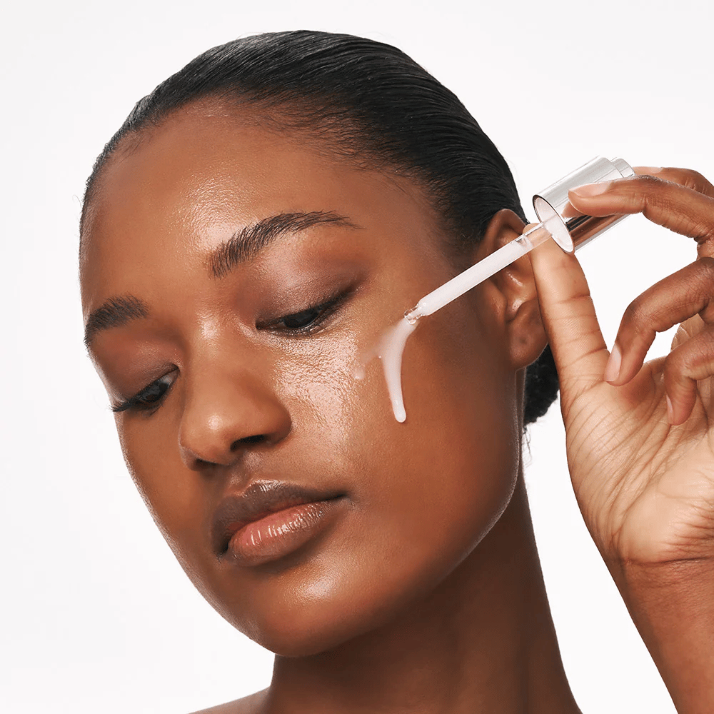 Persoon brengt Deep Collagen Power Boosting Cream in Serum aan op de wang met een pipet. Het serum zorgt voor een stevigere, gehydrateerde huid met glans.