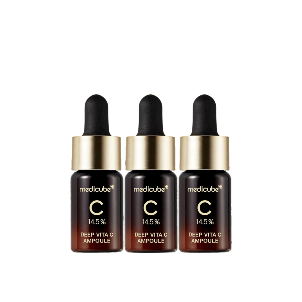 Drie flessen van Medicube Deep Vita C Ampoule, met 14,5% vitamine C, gerangschikt op een rij. De flessen hebben een elegant ontwerp met een donkerbruine basis en een goudkleurige dop. Perfect voor een helderdere huidtint en een egalere huidtextuur.