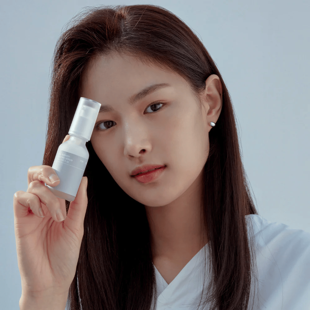 Model houdt Celimax Dual Barrier Boosting Serum, Koreaanse huidverzorging die de huidbarrière versterkt en gevoelige huid kalmeert.