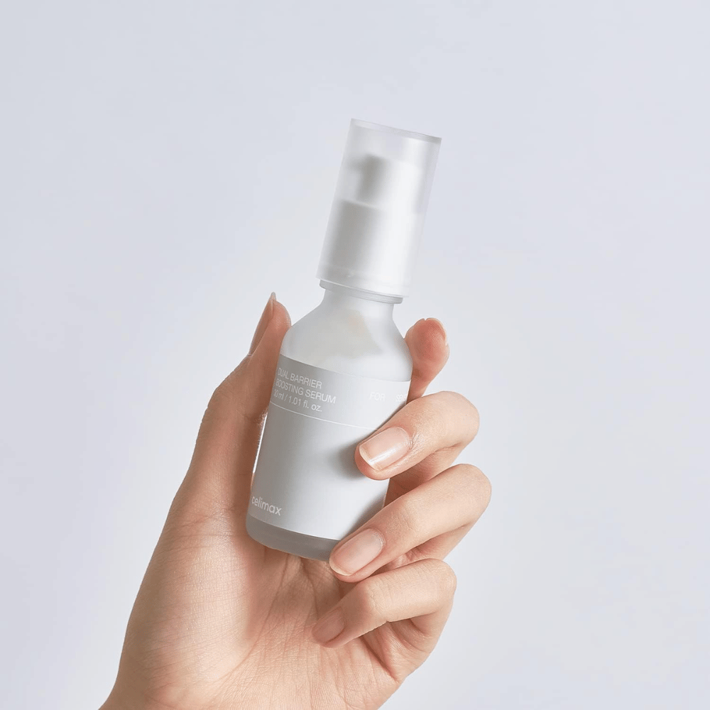 Celimax Dual Barrier Boosting Serum in hand, minimalistische verpakking die Koreaans serum met barrièreversterking voor gevoelige huid toont.