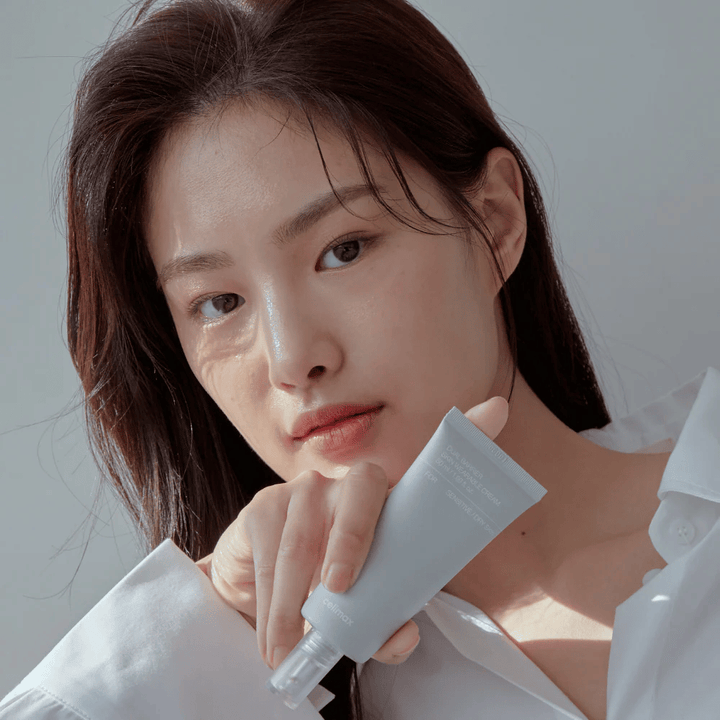 Model die Celimax Dual Barrier Skin Wearable Cream vasthoudt, kalmerende en barrièreversterkende gezichtscrème voor gevoelige huid en droge huid.