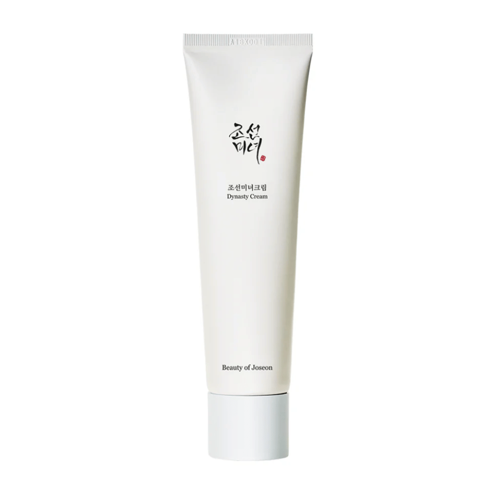 De afbeelding toont een tube van "Beauty of Joseon Dynasty Cream". De slanke, witte tube heeft minimalistische designelementen, inclusief elegante zwarte en rode tekst. Dit huidverzorgingsproduct belooft de huid te voeden en te vitaliseren, wat de historische schoonheidsgeheimen van de Joseon-dynastie weerspiegelt.