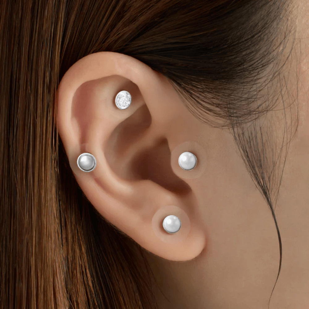 Close-up van een oor met meerdere RETURNITY Ear Therapy Acupressure Patch aangebracht op verschillende delen van het oor voor acupressuur en een stijlvolle look.