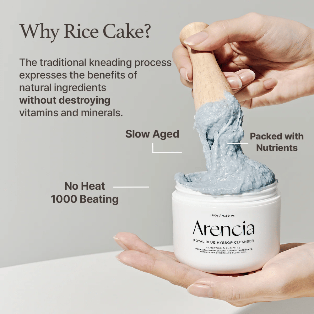 Hand die de reinigingspot "Arencia Royal Blue Hyssop Cleanser" vasthoudt met een houten lepel die de blauwe, mochi-achtige reinigingspasta omhoog tilt. Tekst in de afbeelding beschrijft voordelen van het rijstdeegproces, zoals "Geen hitte", "1000 slagen", "Langzaam gerijpt" en "Boordevol voedingsstoffen".