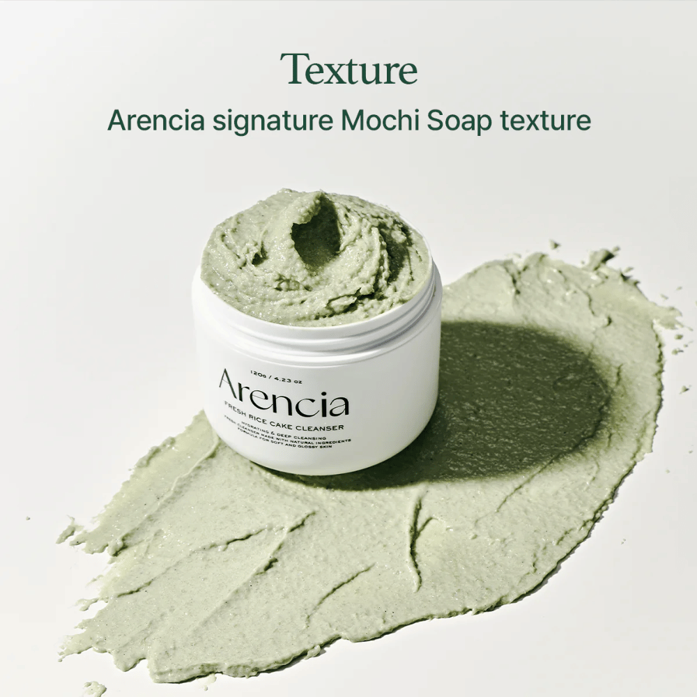 Arencia Fresh Rice Cake Cleanser in een open pot met romige groene mochi-achtige textuur verspreid rond de pot op een witte ondergrond.
