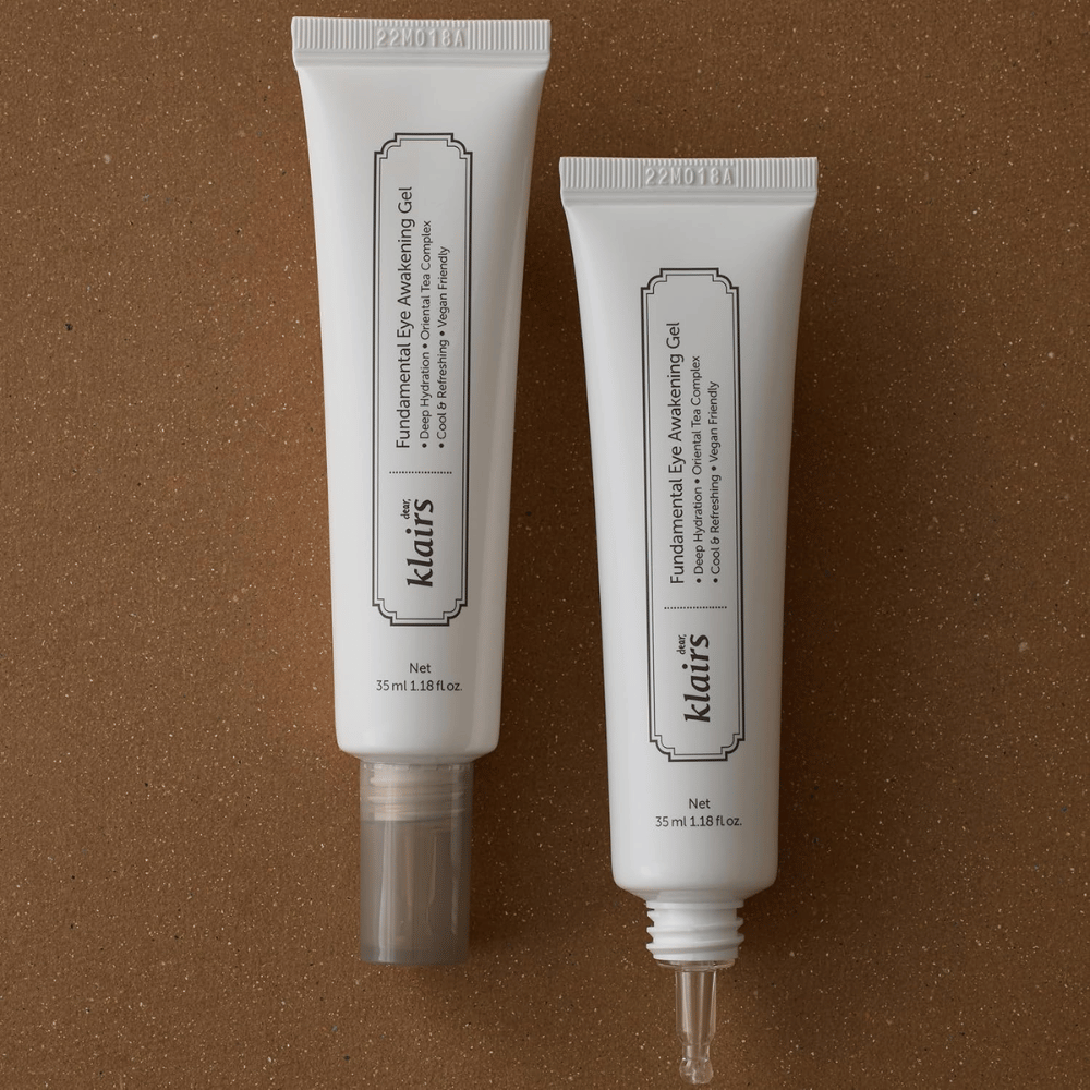 Productafbeelding die Klairs Fundamental Eye Awakening Gel in twee uitvoeringen toont – een gesloten tube en een open tube die de smalle applicatorpunt benadrukt. De verpakking heeft een minimalistisch wit ontwerp en legt de nadruk op de focus van het product op hydratatie, een verkoelend gevoel en verfrissende verzorging voor de oogzone.